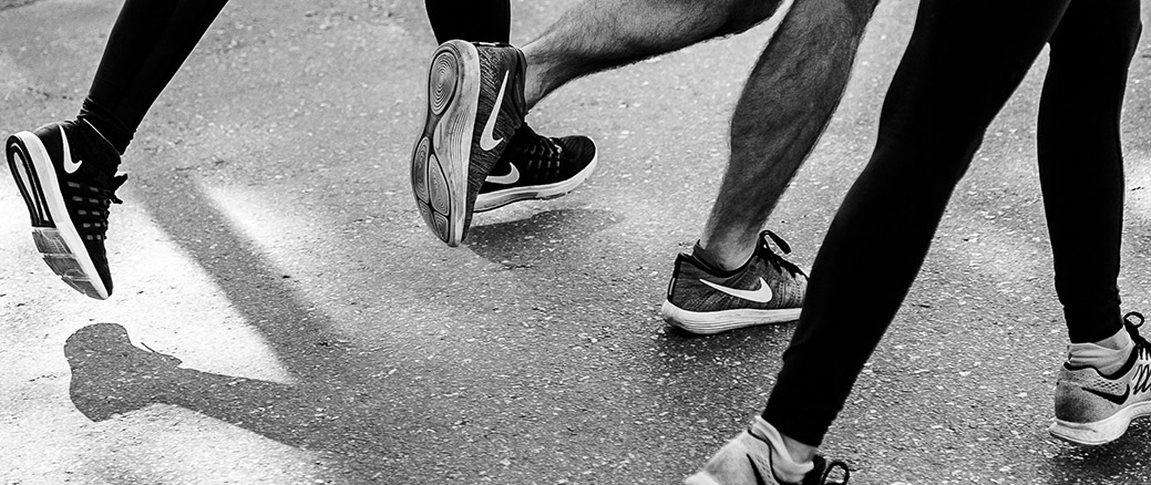 Three young professionals running on street